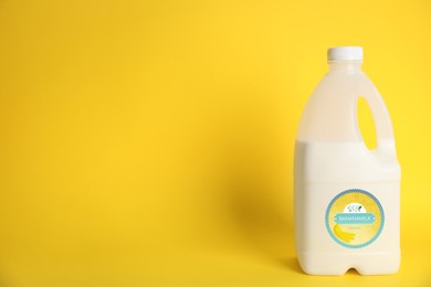 Gallon bottle of banana milk on yellow background, space for text. Vegan product