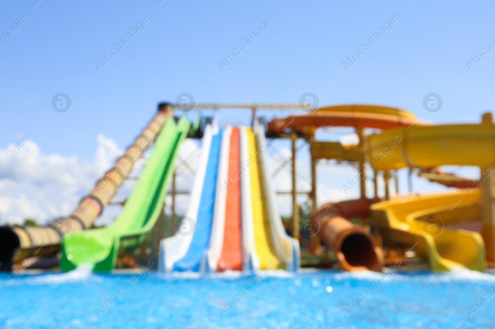 Photo of Different colorful slides in water park, blurred view