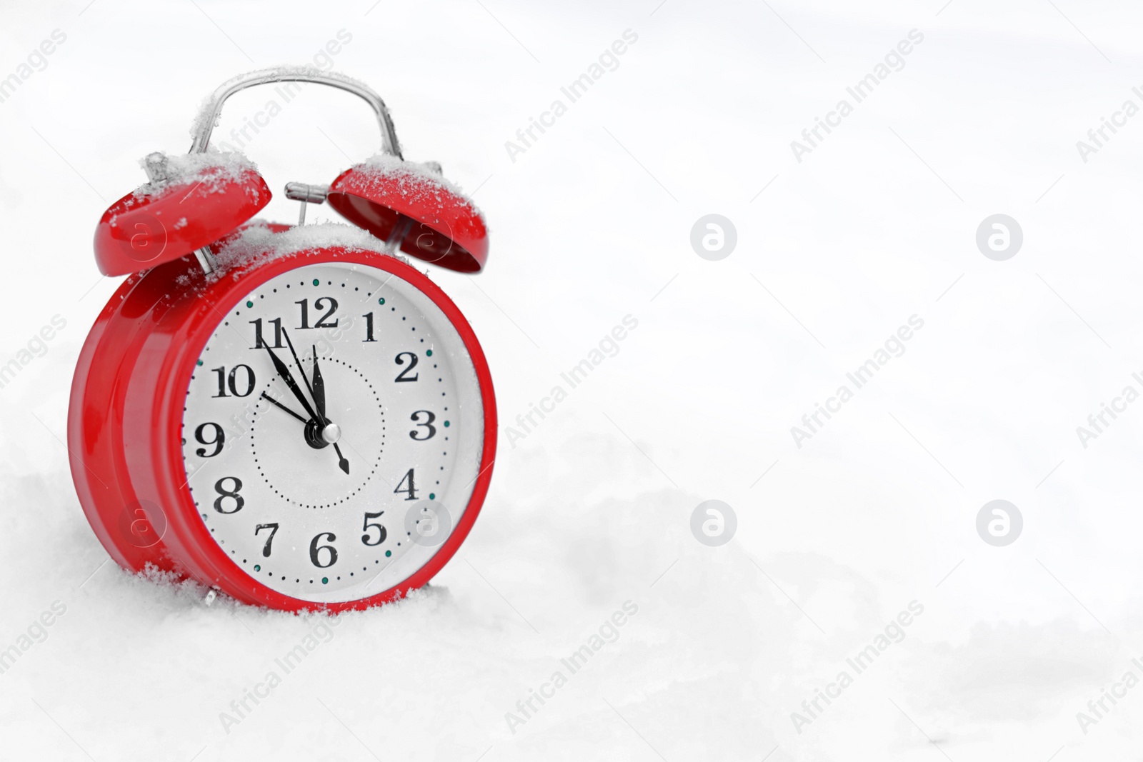 Photo of Red alarm clock on white snow outdoors. Space for text