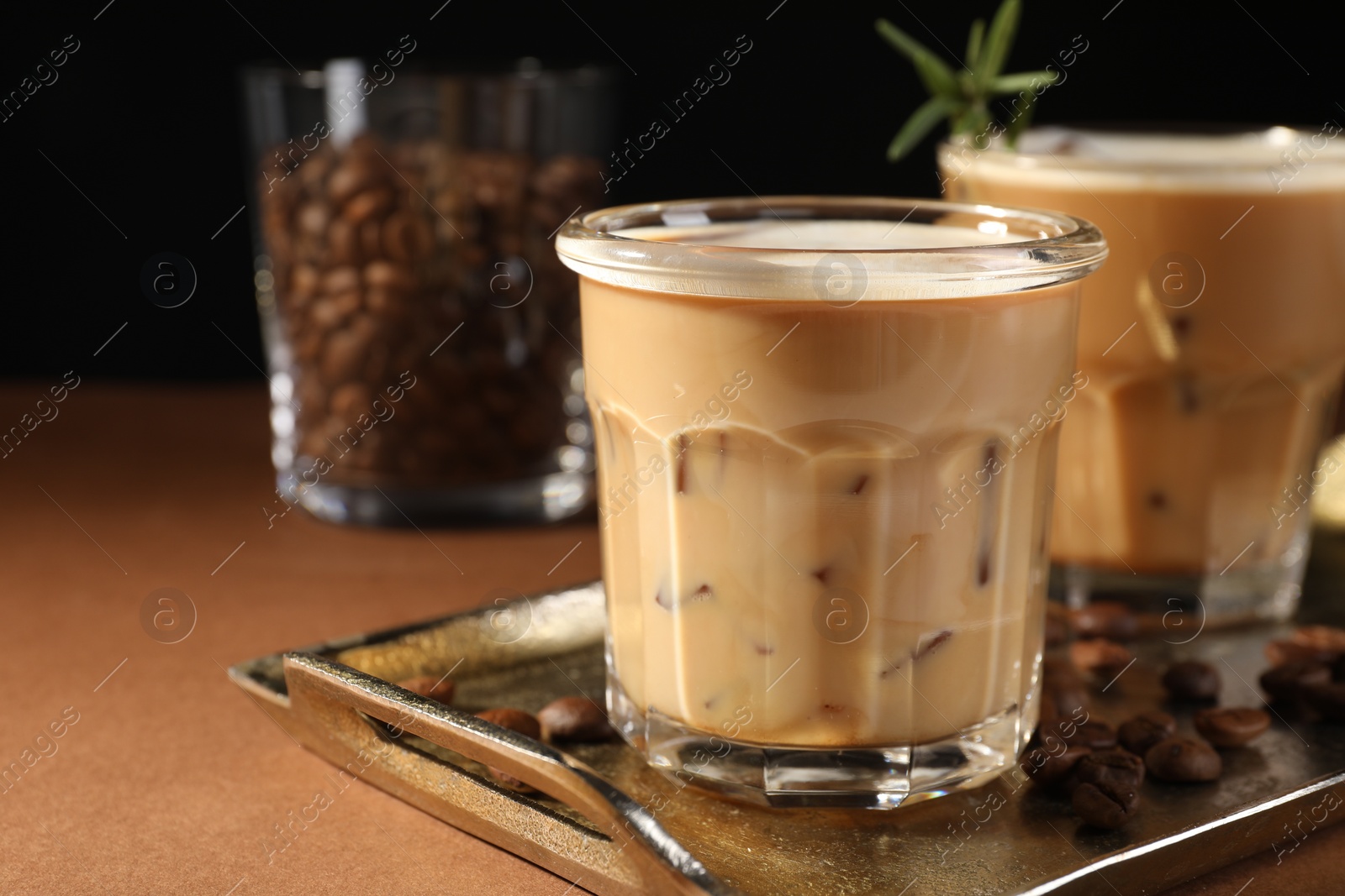 Photo of Refreshing iced coffee with milk in glasses on brown table, closeup