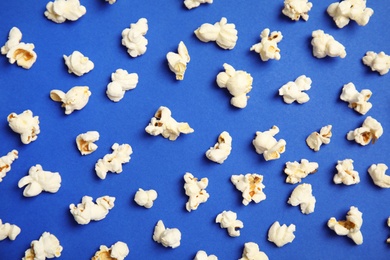 Photo of Tasty fresh popcorn on color background, top view