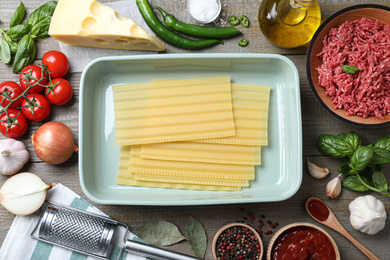 Photo of Fresh ingredients for lasagna on grey wooden table, flat lay