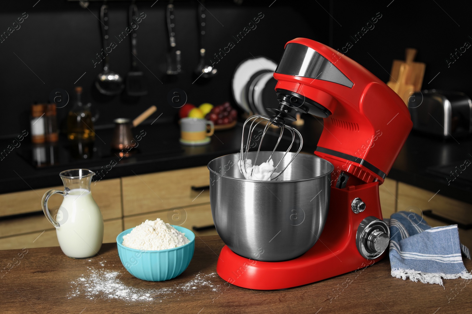 Photo of Modern red stand mixer and ingredients on wooden table in kitchen