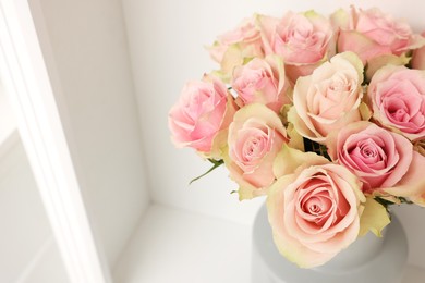 Photo of Beautiful rose flowers on shelf indoors, above view and space for text. Interior design