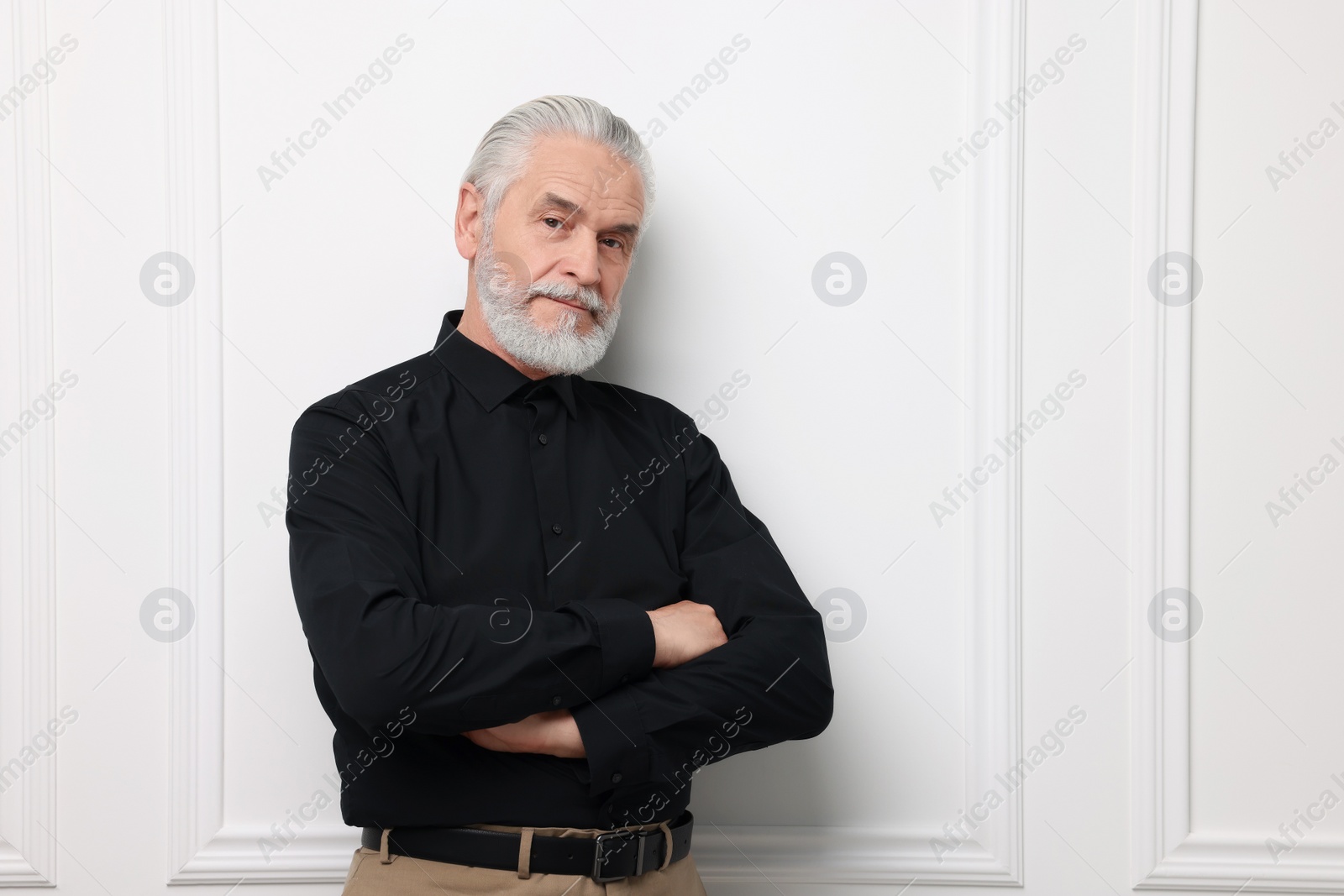 Photo of Portrait of handsome senior man near white wall. Space for text