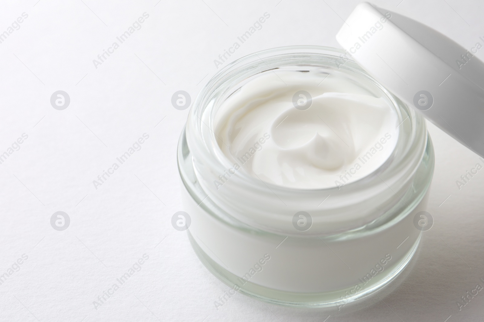 Photo of Jar of face cream on white background, closeup. Space for text