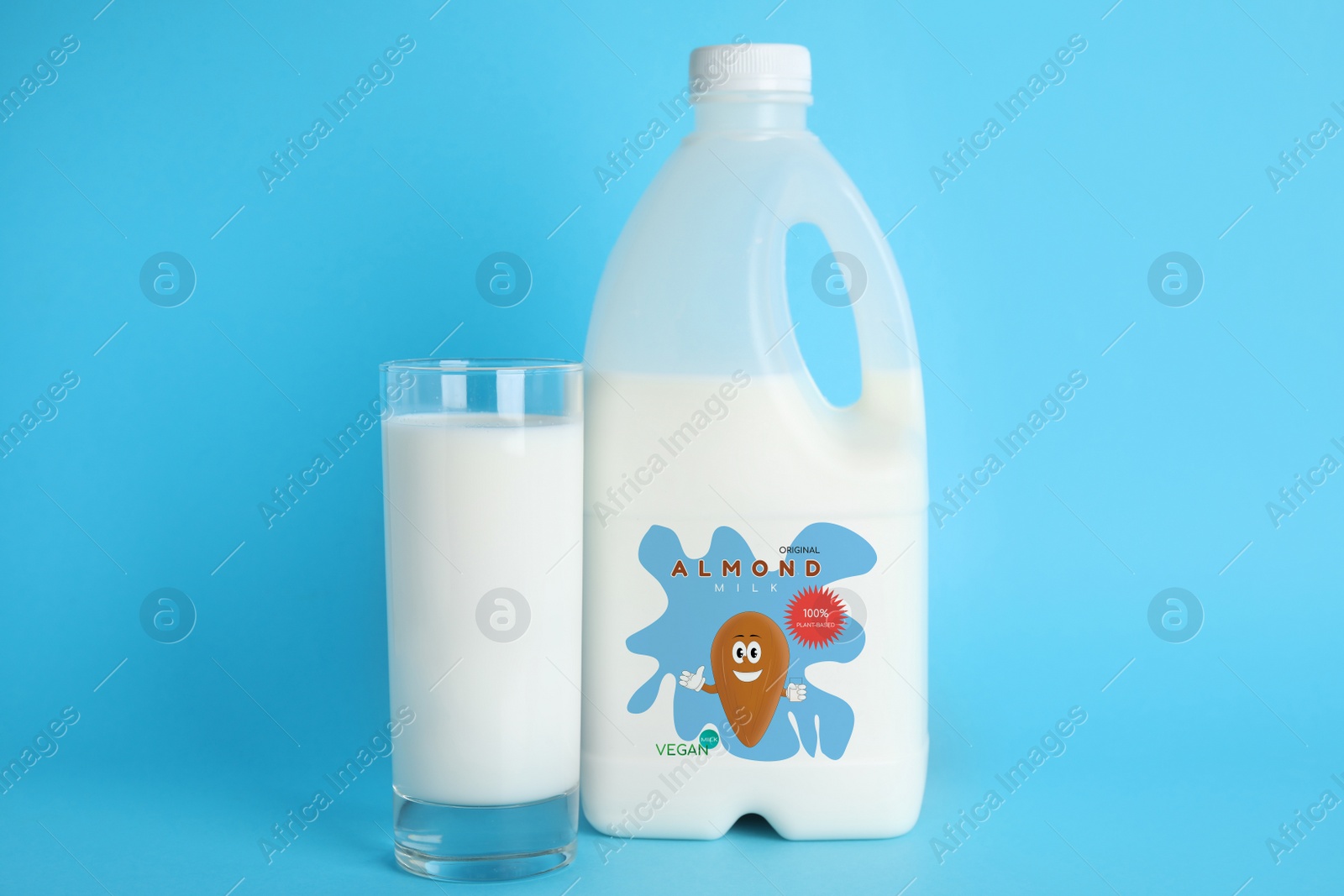 Image of Gallon bottle and glass of almond milk on light blue background. Vegan product