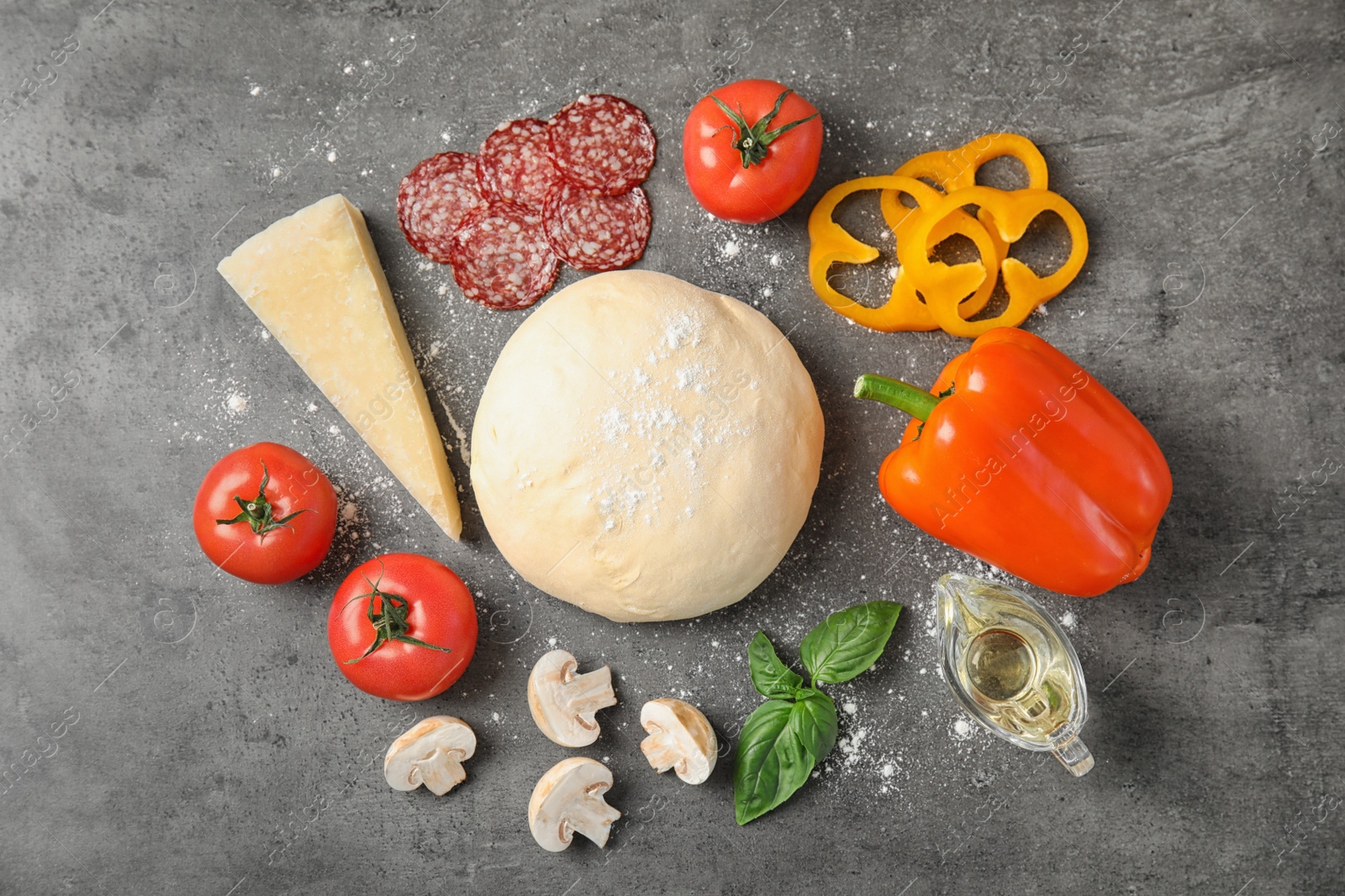 Photo of Flat lay composition with dough and ingredients for pizza on grey table