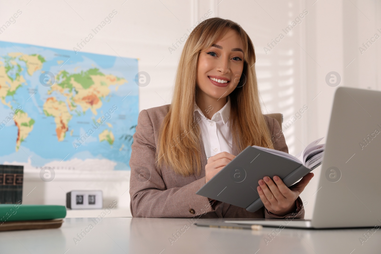 Photo of Happy manager working at desk in travel agency