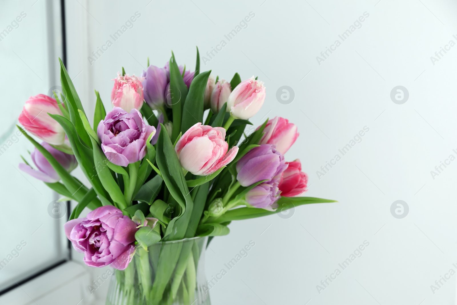 Photo of Beautiful bouquet of colorful tulip flowers indoors. Space for text