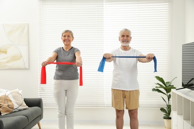 Senior couple doing exercise with fitness elastic bands at home