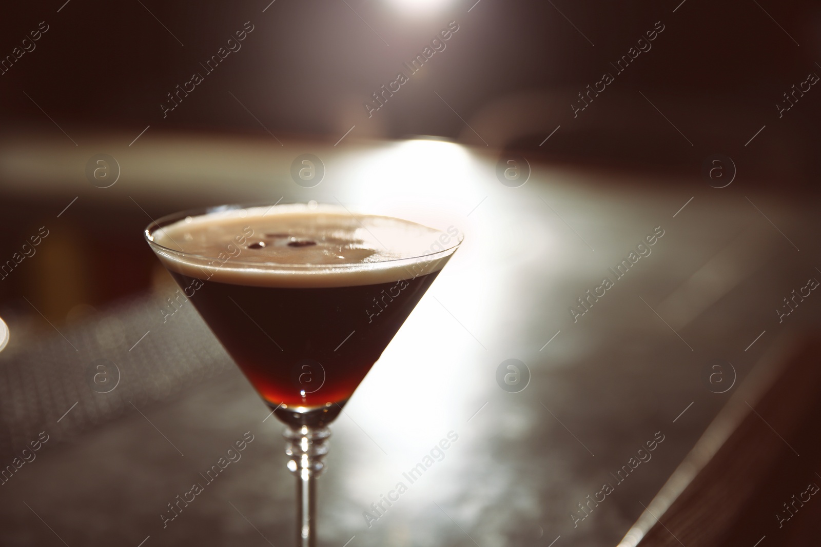 Photo of Glass of martini espresso cocktail in bar, closeup. Space for text