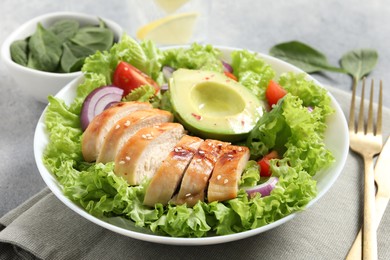 Photo of Delicious salad with chicken, avocado and vegetables served on table, closeup