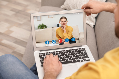 Image of Man using laptop for online consultation with psychologist via video chat, focus on screen