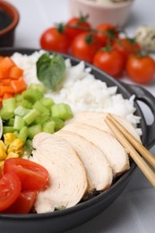 Delicious poke bowl with meat, rice and vegetables on table, closeup