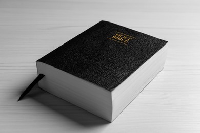 Photo of Holy Bible on white wooden table, closeup