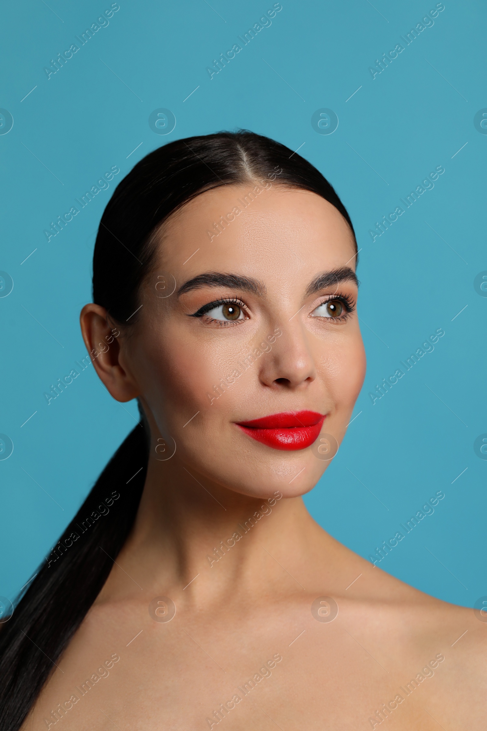 Photo of Attractive smiling woman against light blue background