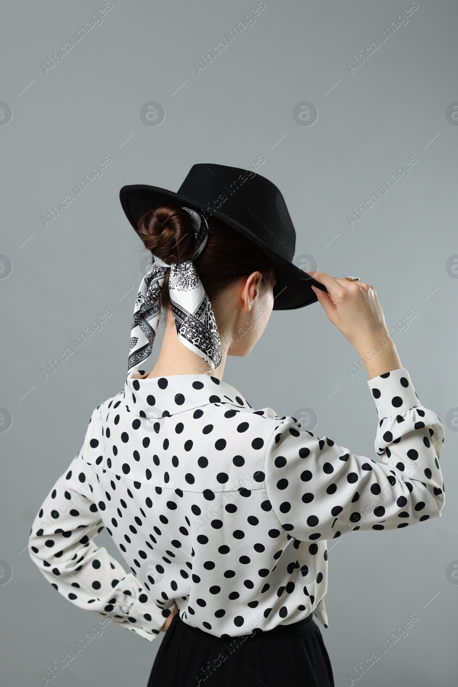 Photo of Woman with black hat and stylish bandana on light grey background