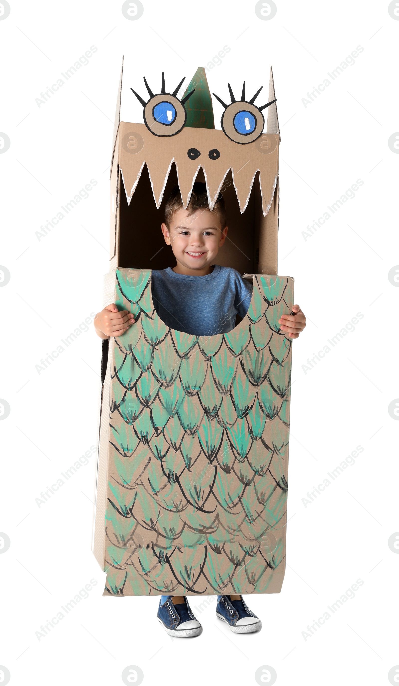 Photo of Cute little boy playing with cardboard dragon on white background