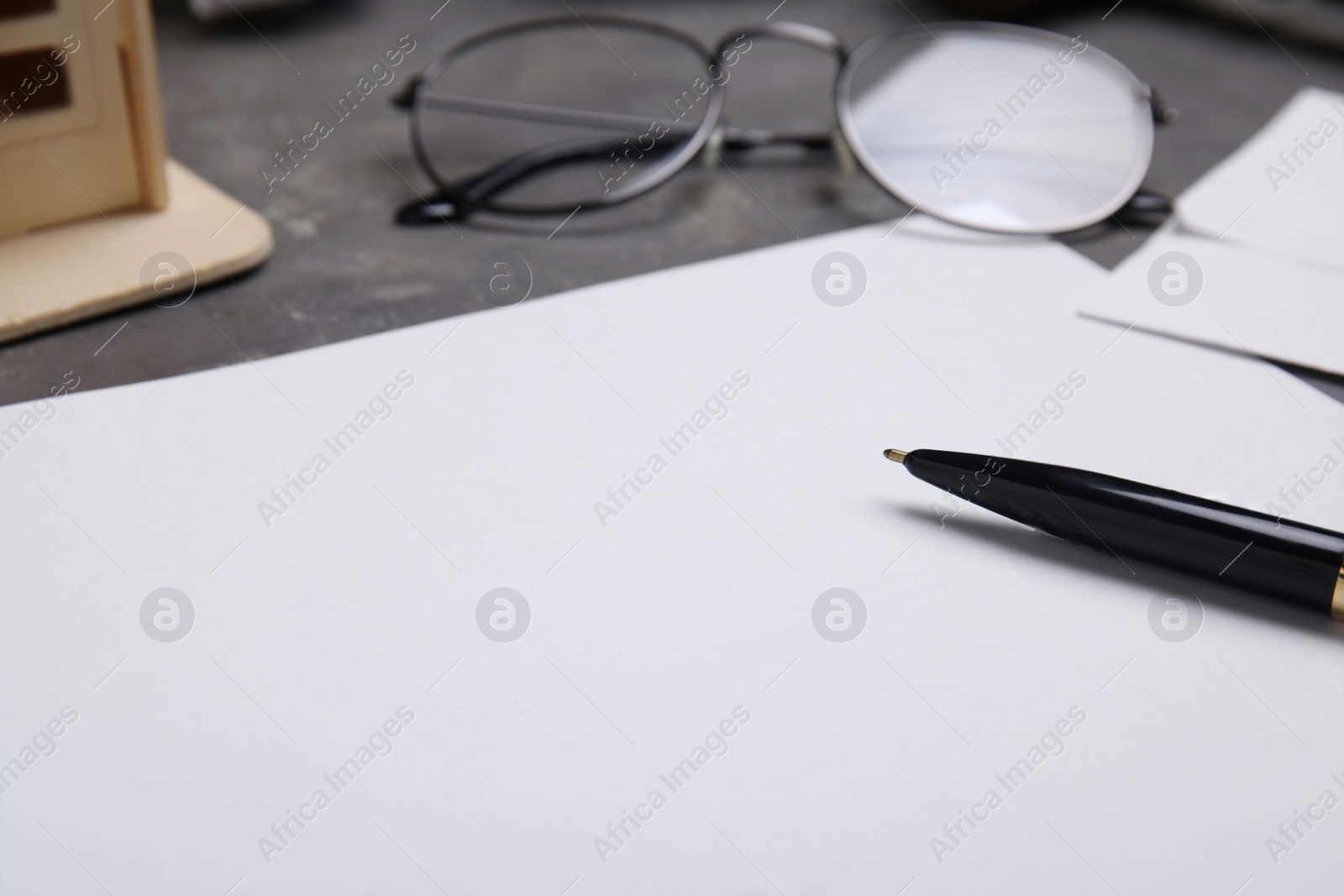 Photo of Last will and testament with pen near glasses on grey table, closeup