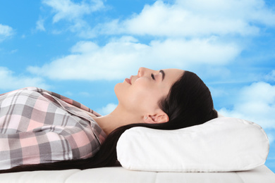 Image of Young woman sleeping in bed. Blue sky on background