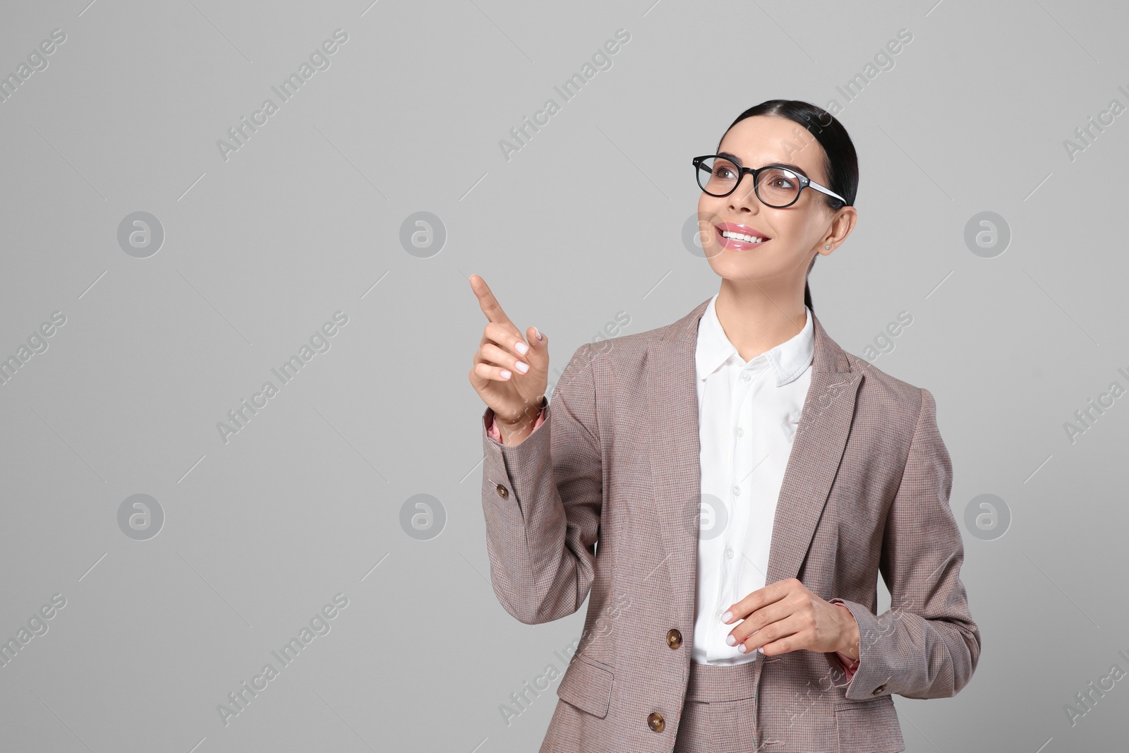 Photo of Beautiful real estate agent in nice suit on grey background. Space for text