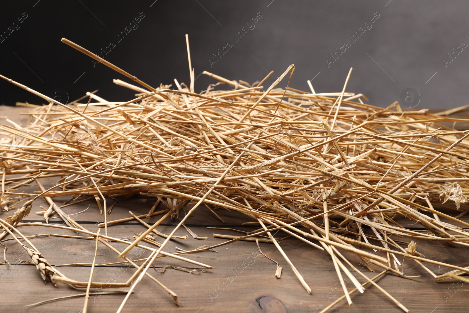 Photo of Pile of dried straw on wooden table