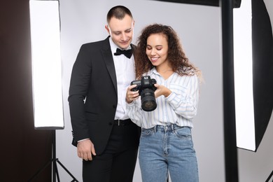 Photo of Handsome model with professional photographer in studio