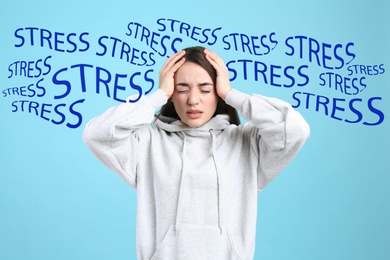 Stressed young woman and text on light blue background