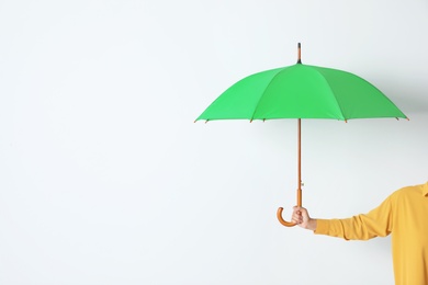 Person holding open umbrella on white background with space for design