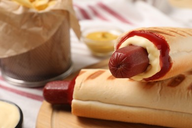 Photo of Delicious french hot dogs on table, closeup