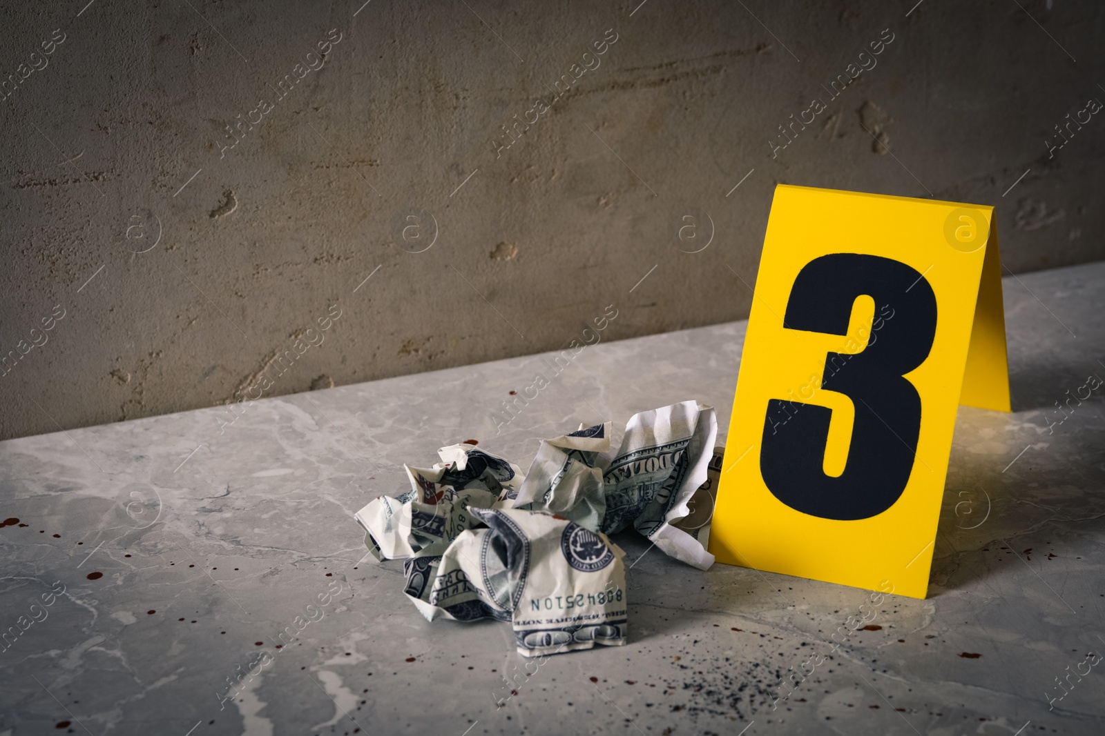 Photo of Crime scene marker and crumpled dollars on light grey marble table