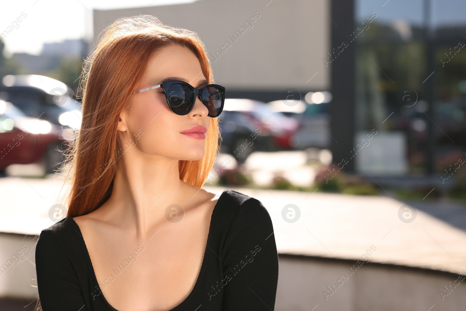 Photo of Beautiful woman in sunglasses on city street, space for text