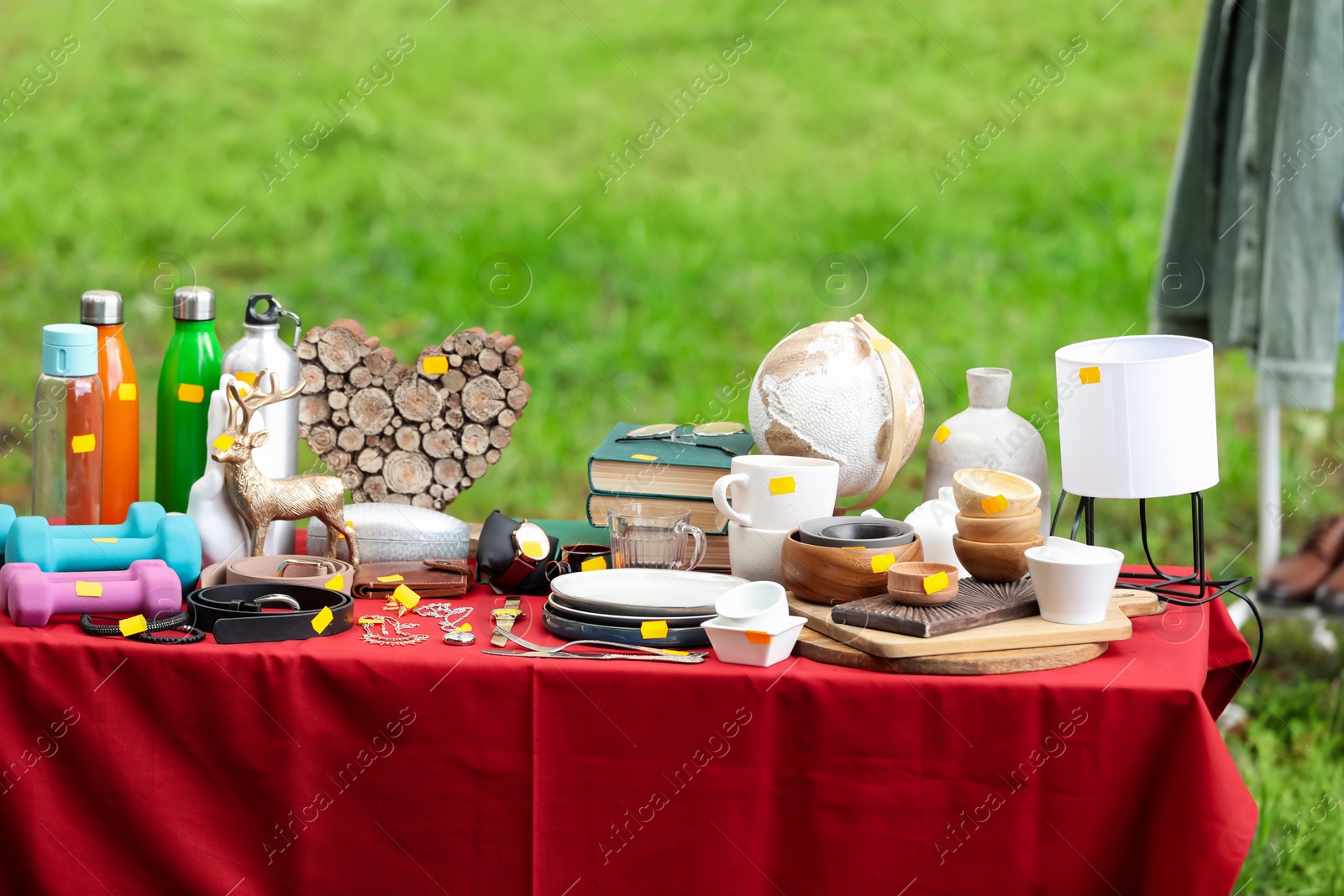 Photo of Different items on table outdoors. Garage sale