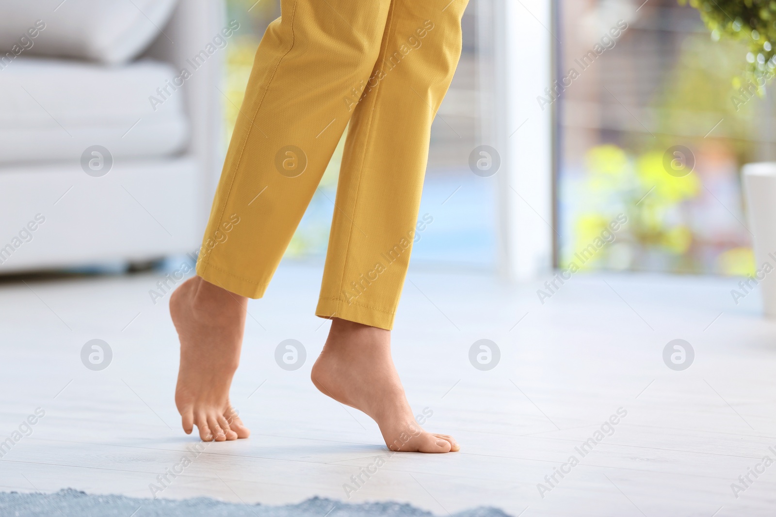 Photo of Woman walking barefoot at home, space for text. Floor heating