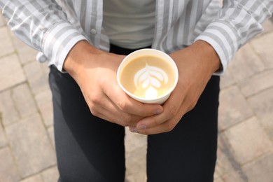 Photo of Coffee to go. Man with paper cup of drink outdoors, closeup