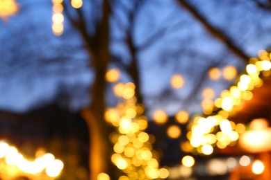 Photo of Blurred view of beautiful Christmas lights outdoors. Bokeh effect