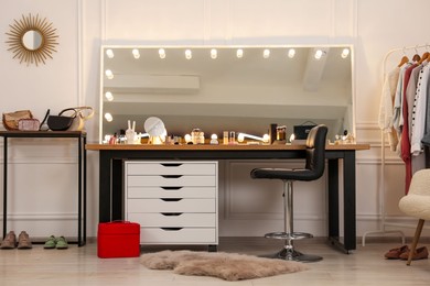Makeup room. Stylish dressing table with mirror and chair