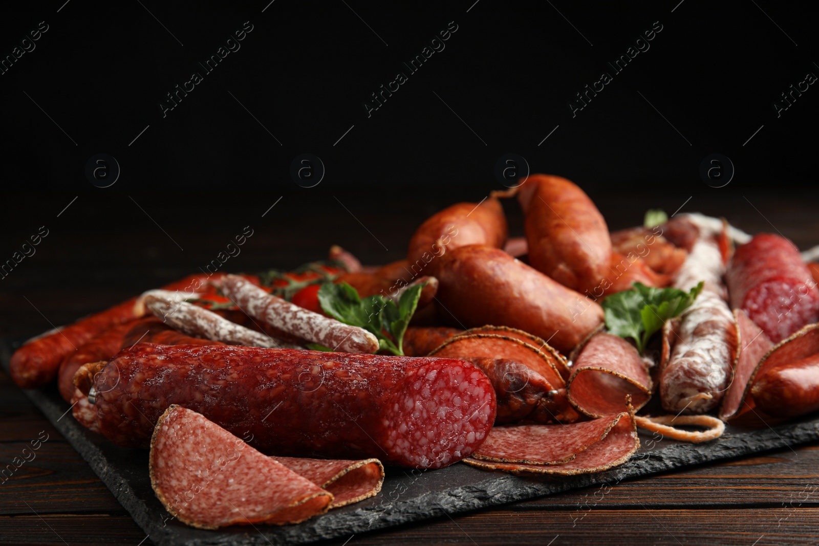 Photo of Different tasty sausages on wooden table, closeup