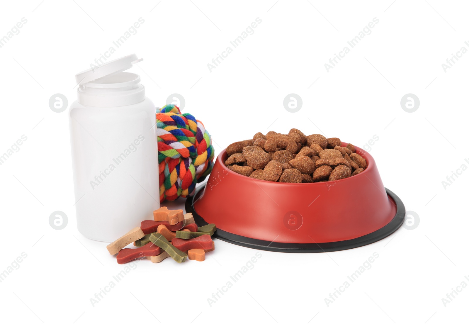 Photo of Dry pet food in bowl, vitamins and toy isolated on white