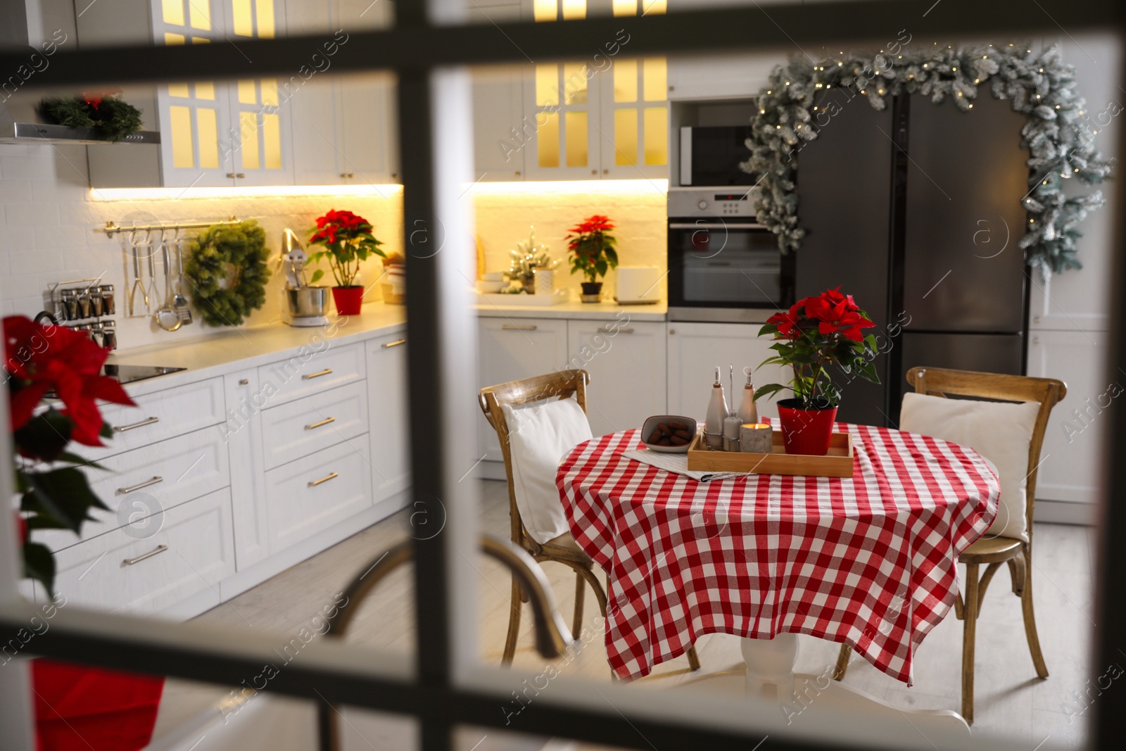 Photo of Beautiful kitchen interior with Christmas decor, view through window