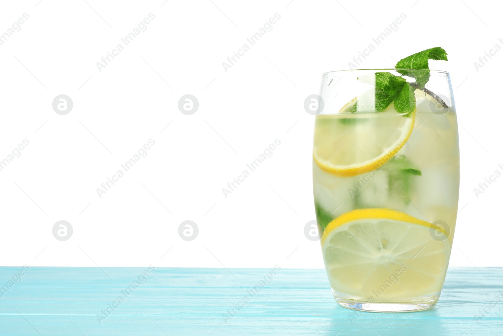 Photo of Glass of refreshing lemonade with mint on blue wooden table against white background. Summer drink