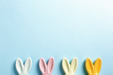 Photo of Flat lay composition of Easter bunny ears on color background, space for text