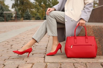 Stylish woman with trendy leather bag on city street, closeup