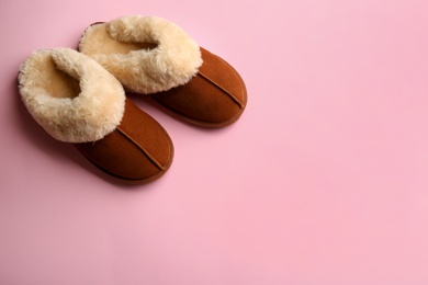 Pair of stylish soft slippers on pink background, flat lay. Space for text