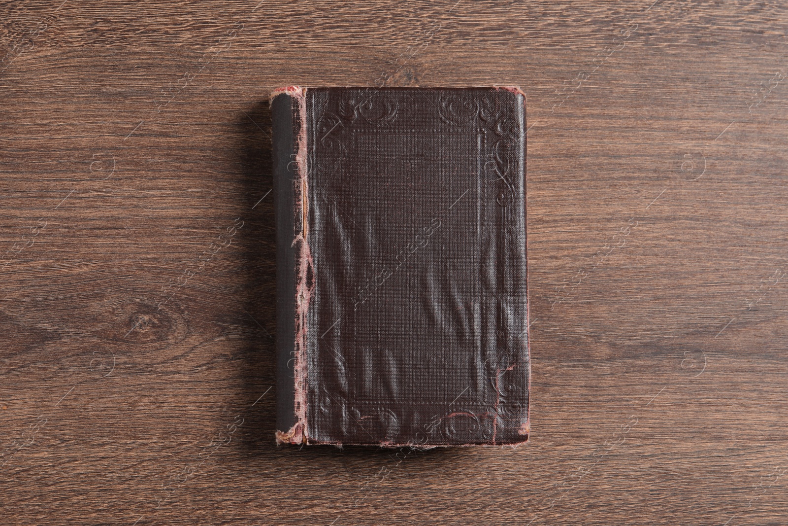 Photo of Old hardcover book on wooden table, top view