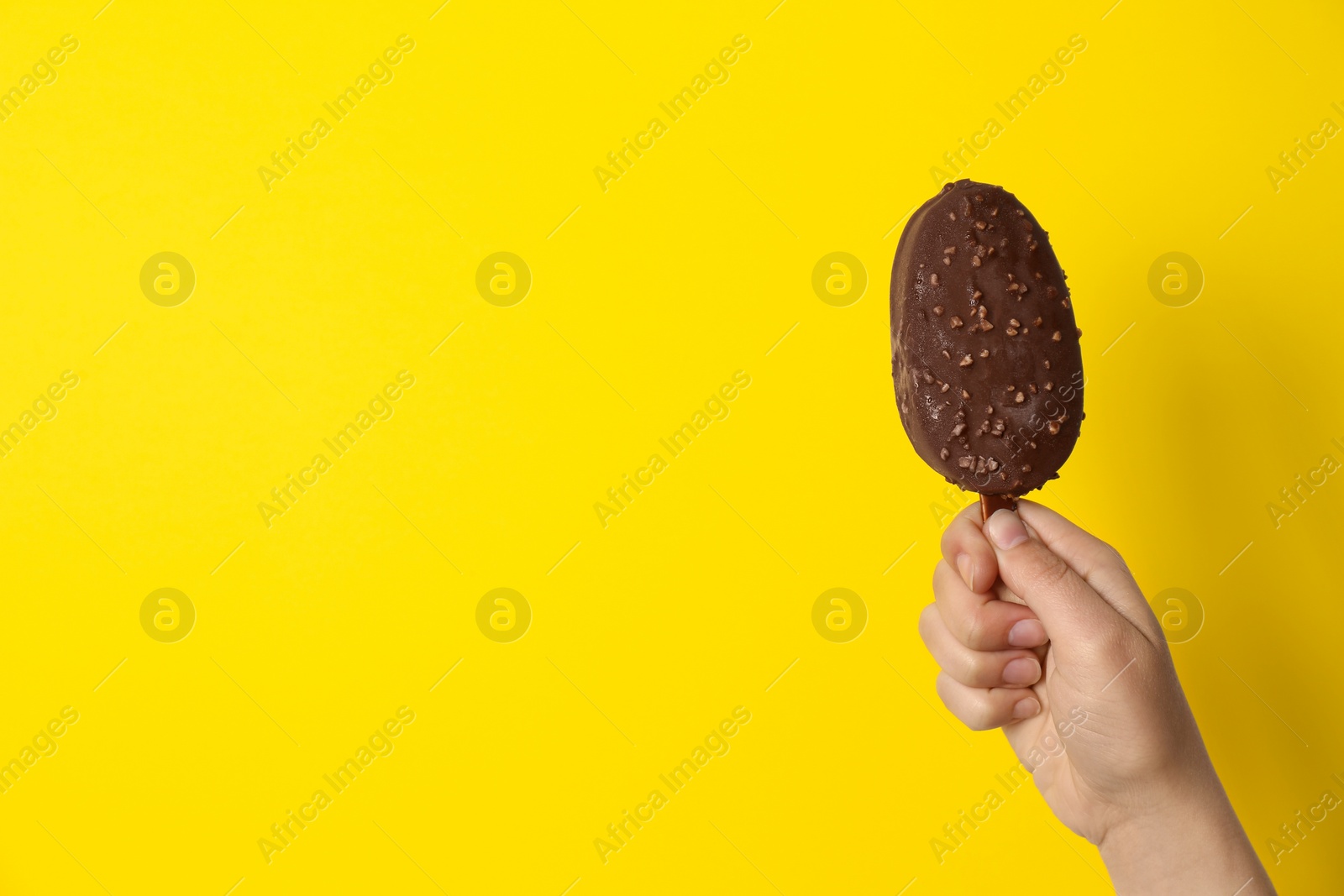 Photo of Woman holding delicious ice cream with chocolate against color background, space for text