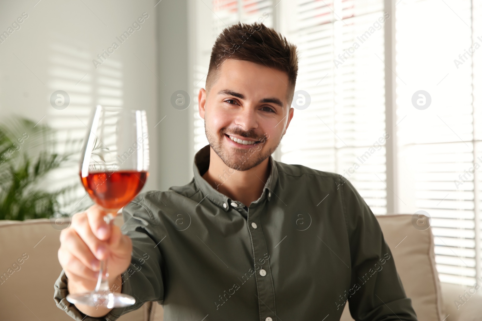 Photo of Man drinking wine while having online video conference at home, view from web camera. Social distancing during coronavirus pandemic