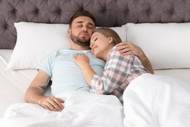 Photo of Young couple sleeping together in bed at home