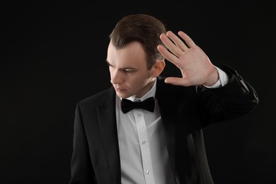 Photo of Young man covering face with hand on black background